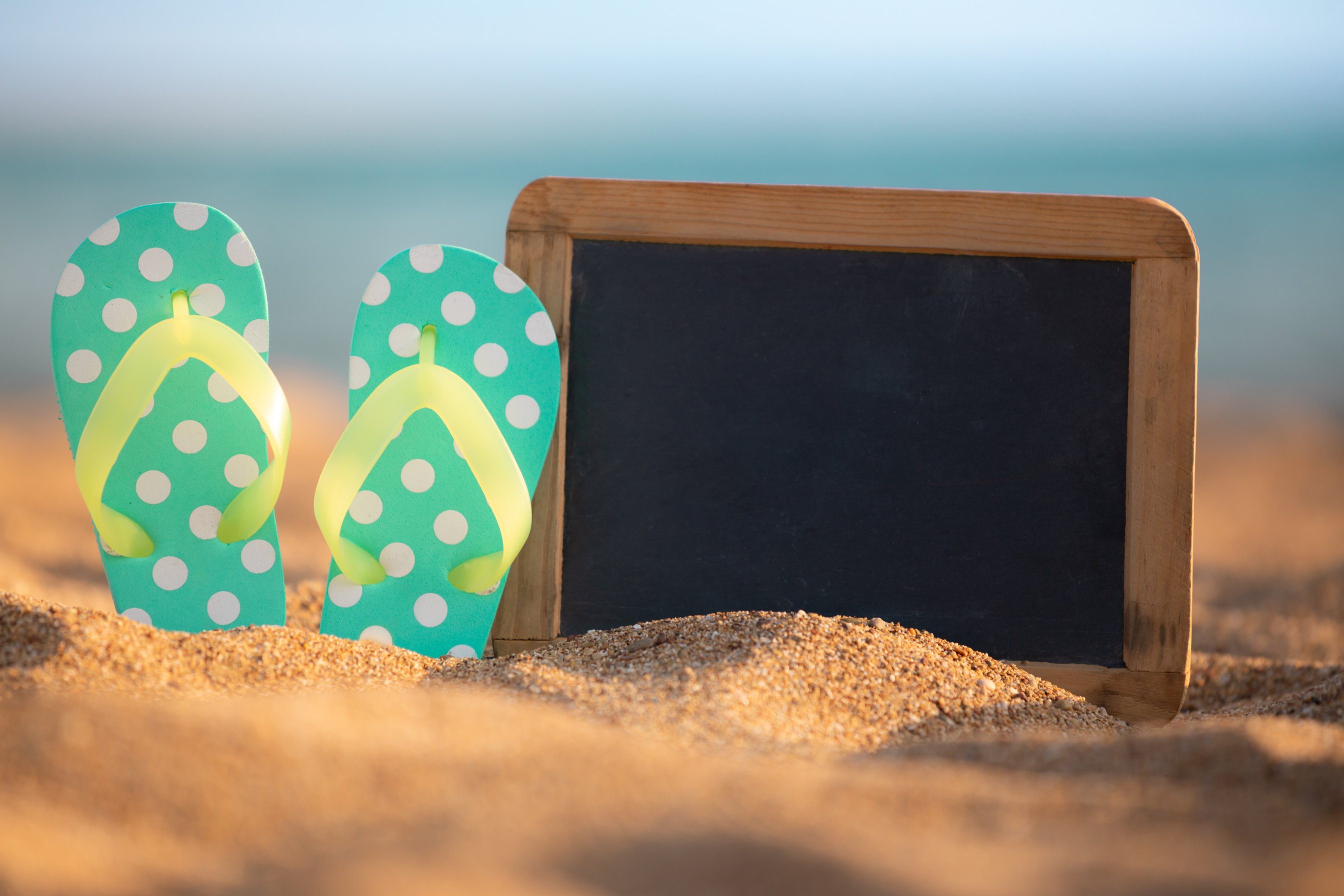 Slippers and Mini Chalkboard on Sand